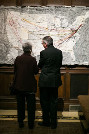 A coupl look at a map of the United States made of fabric and using different color yarn to illustrate the books' travels.